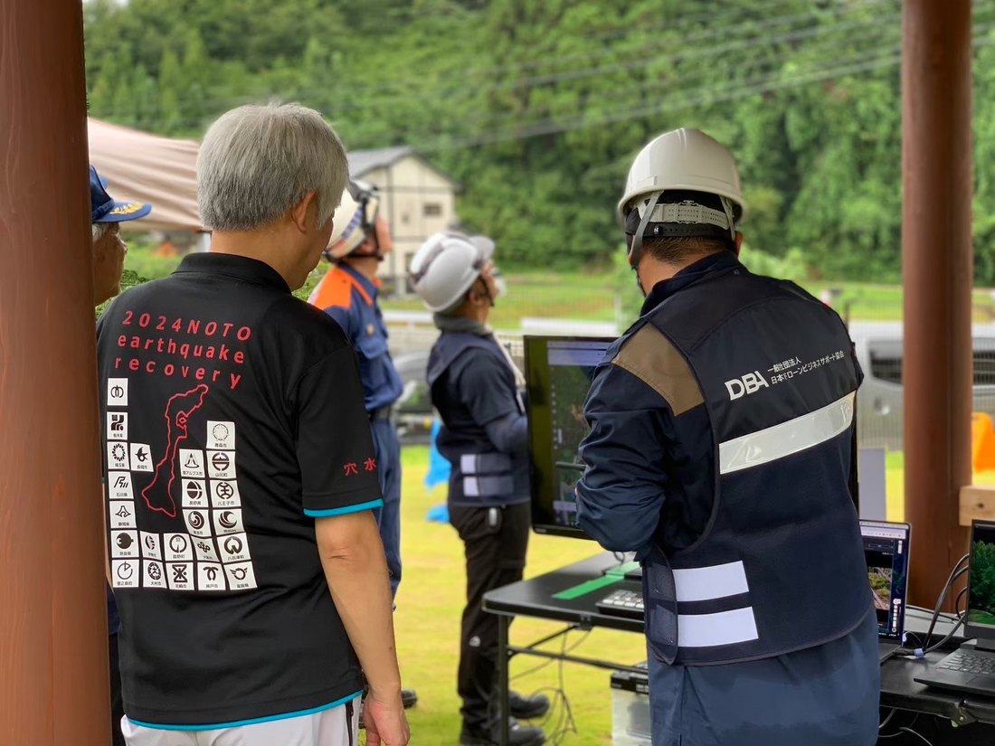 本部テントでモニターを確認する